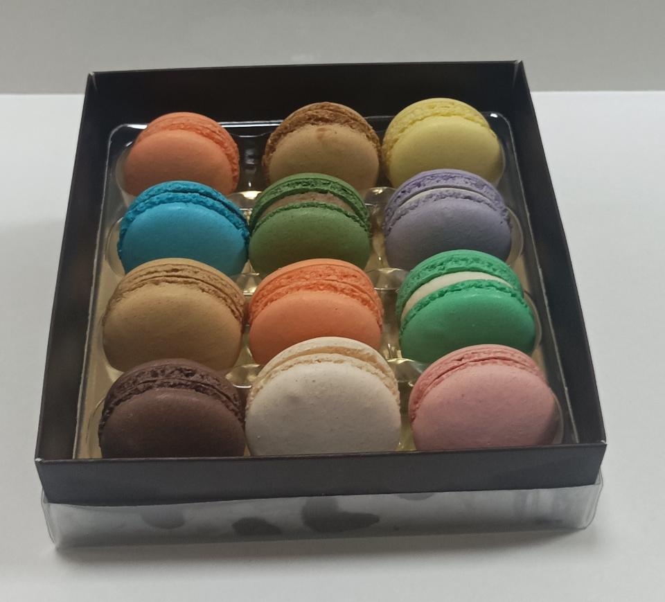 Cajas envueltas para regalo con pasteles artesanales, chocolates y mini pasteles.