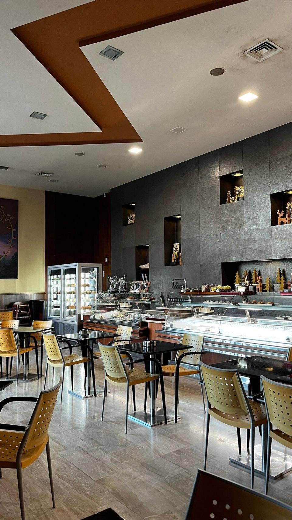 Exterior de una acogedora panadería artesanal con cartel de “Pastelería El Carmen”