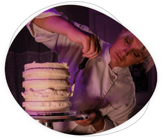 Panadero artesano decorando un pastel con crema fresca y frutas.
